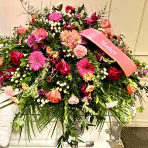 Honor a beautiful life with a pink and purple casket spray from Flowerland Florist in Sulphur Springs, TX. Featuring pink daisies, roses, carnations, and lush blooms in soft, elegant tones—perfect for funeral and memorial services. Local delivery available.