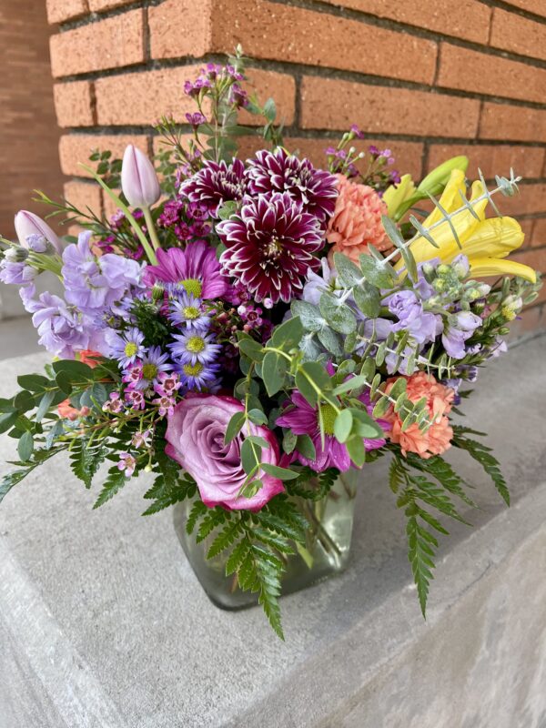 Brighten someone’s day with “Blooming Joy” from Flowerland Florist in Sulphur Springs, TX. Bursting with vibrant daisies, hydrangeas, carnations, and more in cheerful shades of pink, orange, purple, and green. A joyful floral arrangement for any occasion. Local delivery available.