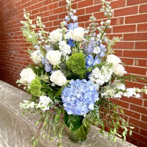 Make a serene statement with “Ocean Whisper” from Flowerland Florist in Sulphur Springs, TX. This elegant arrangement features blue hydrangeas, white roses, and cascading greenery—perfect for sympathy, memorials, or peaceful home décor. Local delivery available.