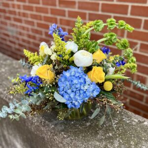 Capture calm and beauty with “Blue Meadow” from Flowerland Florist in Sulphur Springs, TX. Featuring dreamy blue and yellow hydrangeas paired with lush peonies, this elegant arrangement brings a touch of nature’s serenity to any space. Local delivery available.