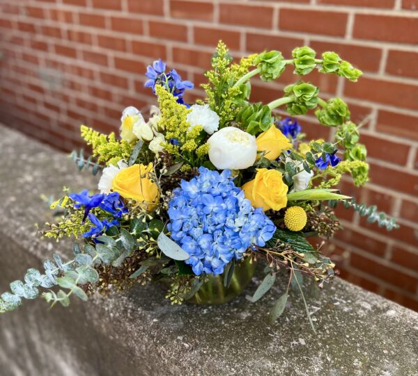 Capture calm and beauty with “Blue Meadow” from Flowerland Florist in Sulphur Springs, TX. Featuring dreamy blue and yellow hydrangeas paired with lush peonies, this elegant arrangement brings a touch of nature’s serenity to any space. Local delivery available.